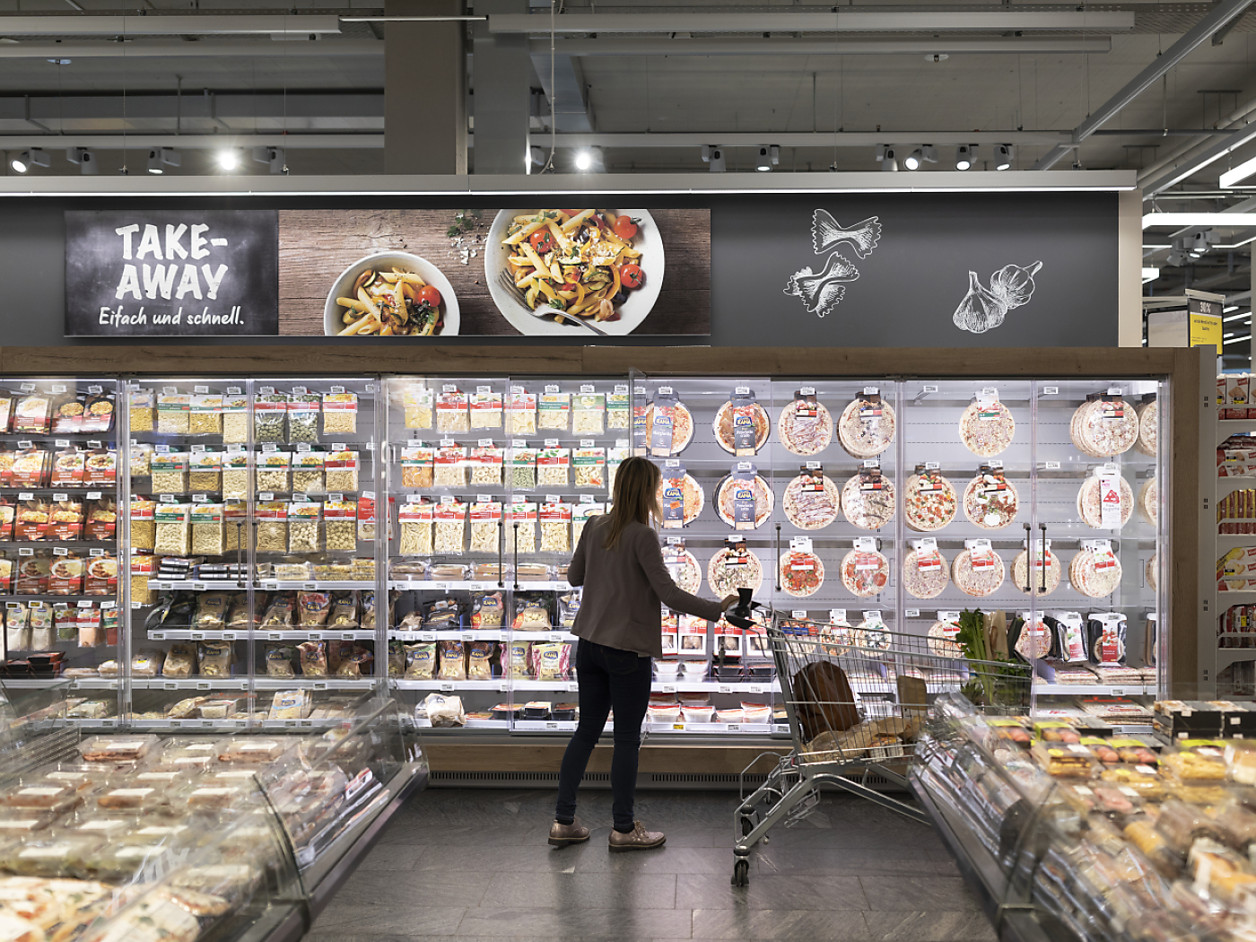 persona davanti al frigo di un supermercato