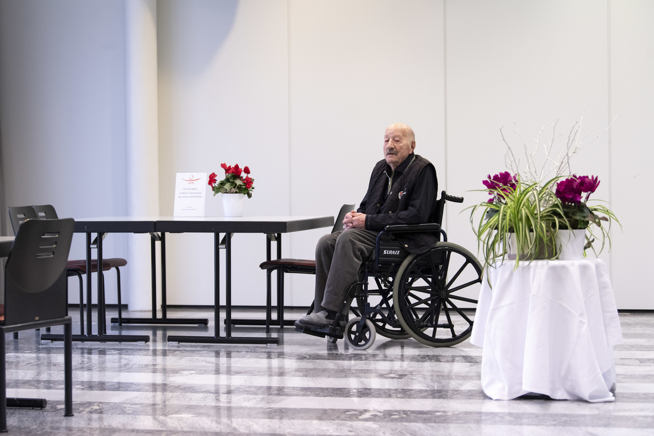 Personnes âgées en fauteuil roulant seule dans une salle.