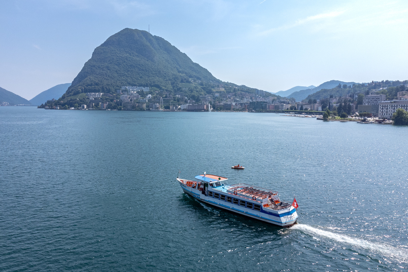 Battello della SNL solca le acque del Lago di Lugano, all'ombra del San Salvatore.