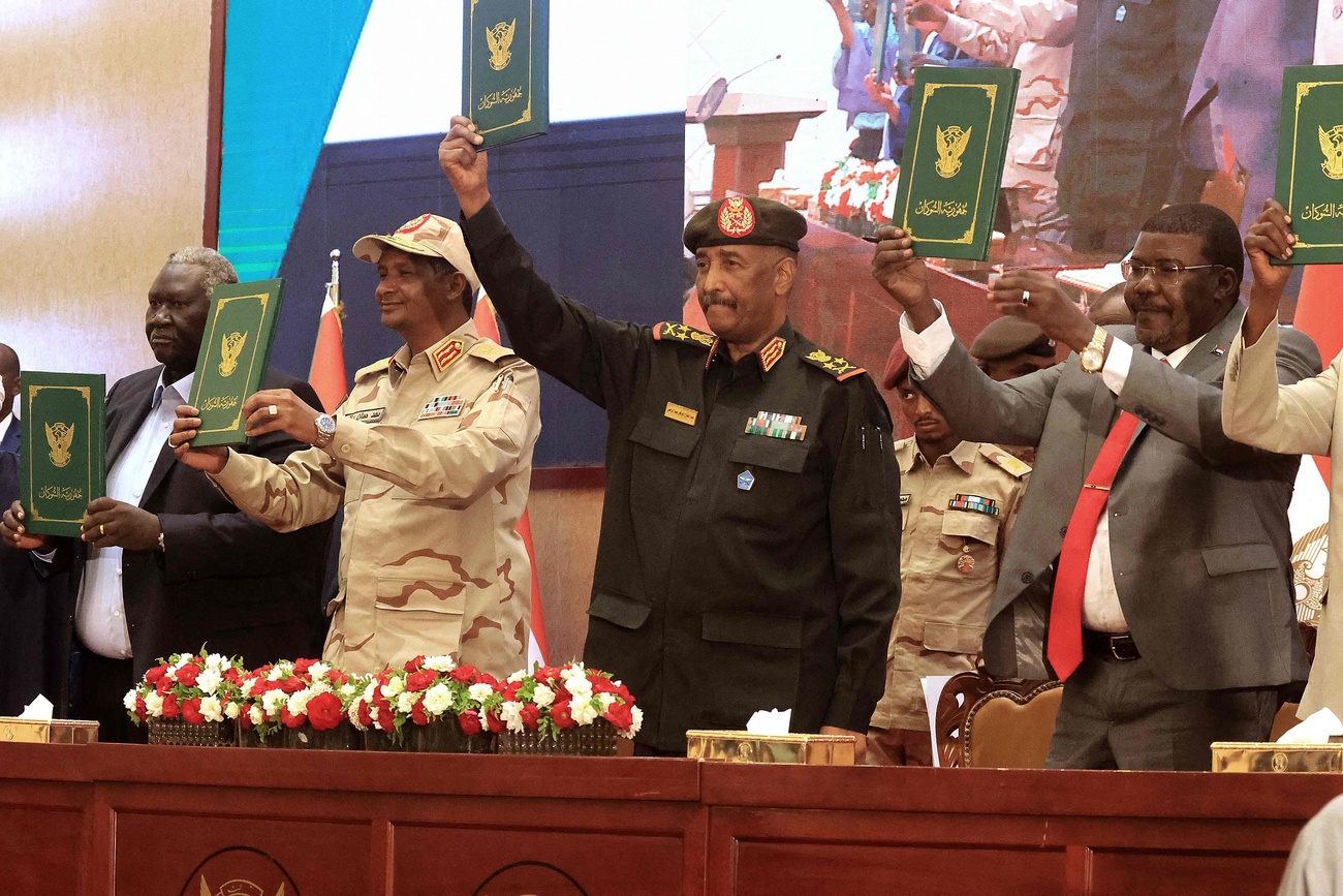 Sudan's Army chief Abdel Fattah al-Burhan (C R) and paramilitary commander Mohamed Hamdan Dagalo (C L) lift documents alongside civilian leaders following the signing of an initial deal aimed at ending a deep crisis caused by last year's military coup, in the capital Khartoum on December 5, 2022. -