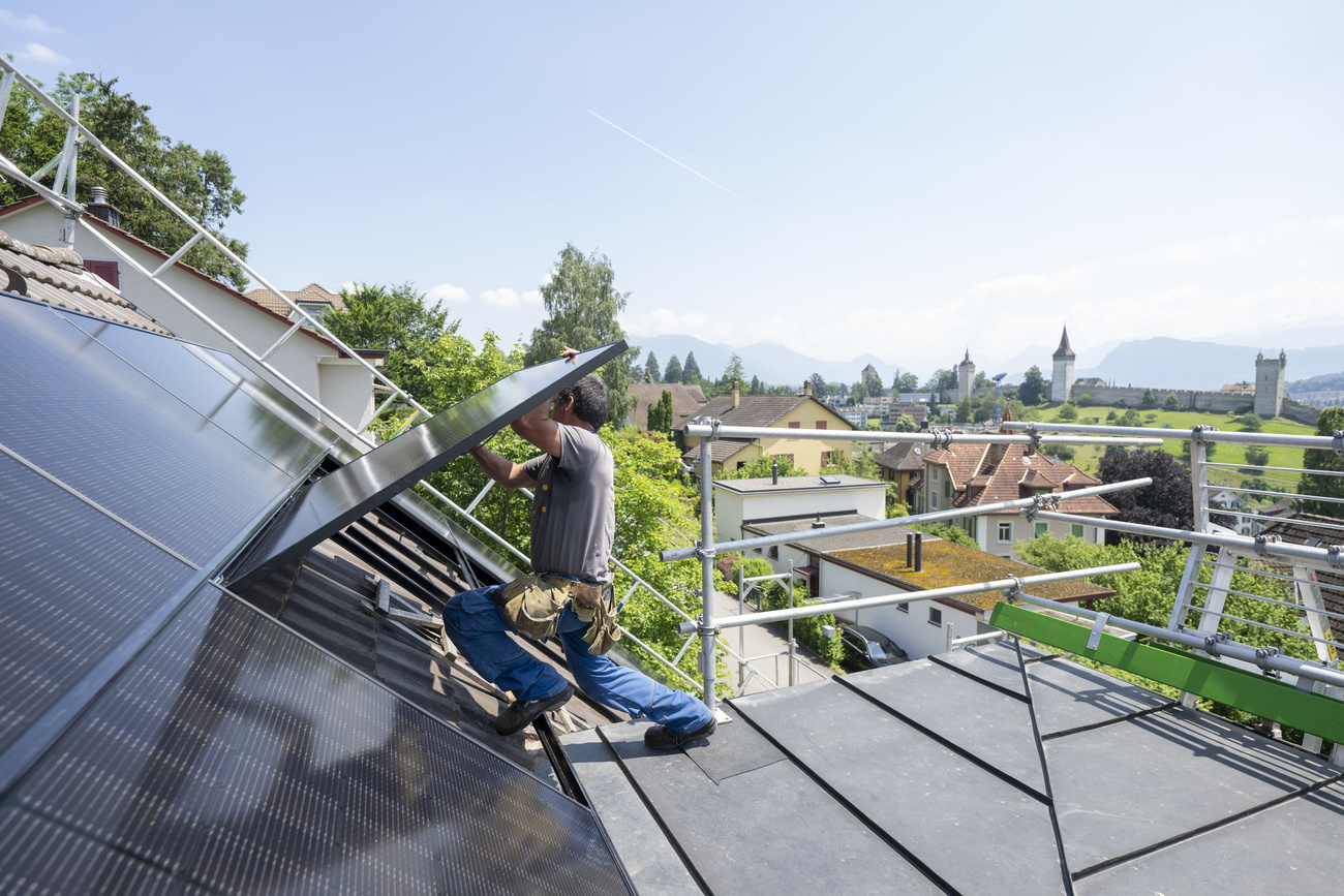 un operaio installa un pannello solare su un tetto