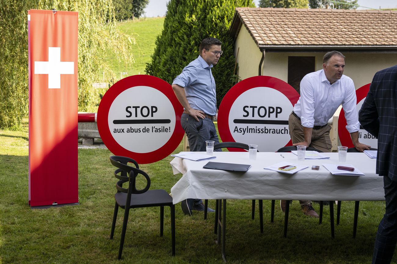 Marcel Dettling, Praesident und Nationalrat, rechts, und Nationalrat Nicolas Kolly von der SVP Schweiz, sprechen an einer Medienkonferenz zur Schweizer Asyl-und Migrationspolitik, am Dienstag, 30. Juli 2024, in Giffers. Sie werfen Bundesrat Beat Jans versagen in der Asylpolitik vor. (KEYSTONE/Peter Schneider).