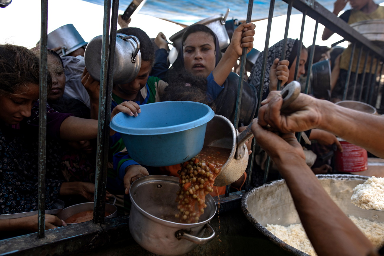 Civili attendono un pasto a Gaza.