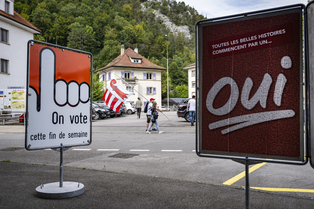 Deux personnes avec un drapeau jurassien dans une rue