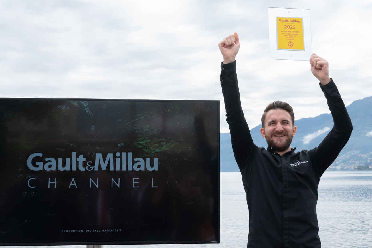 Picture of a man cheering in front of lake with prize in his hand