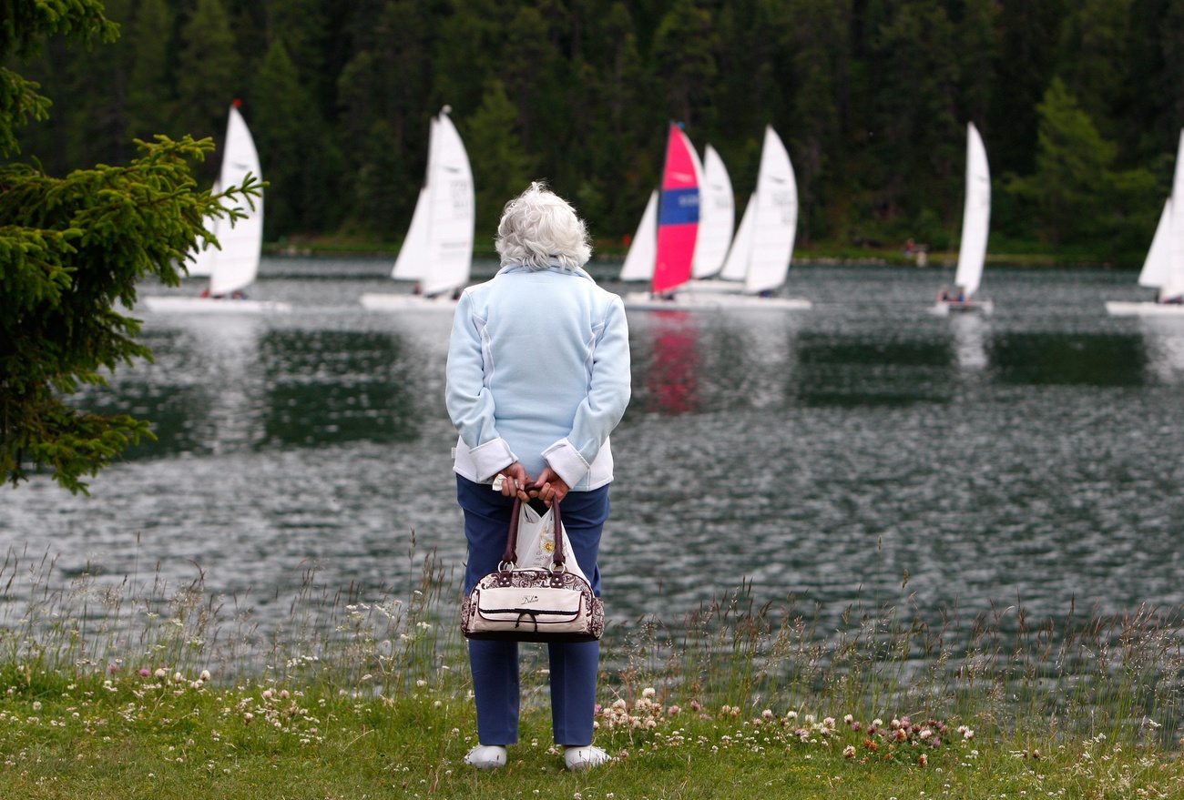 old woman looking at boats on the lake