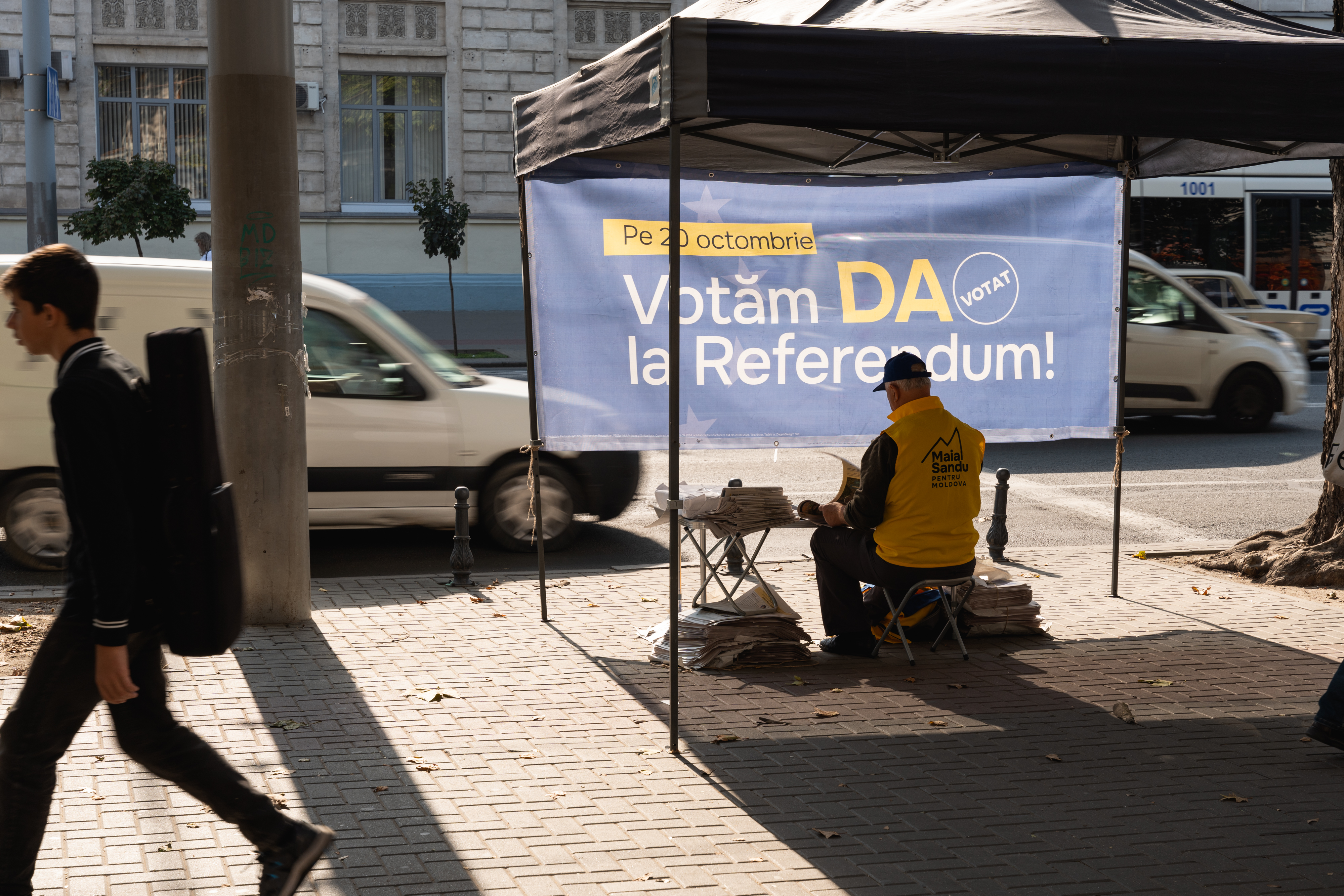 Wahlhelfer sitzt unter einem Pavillion