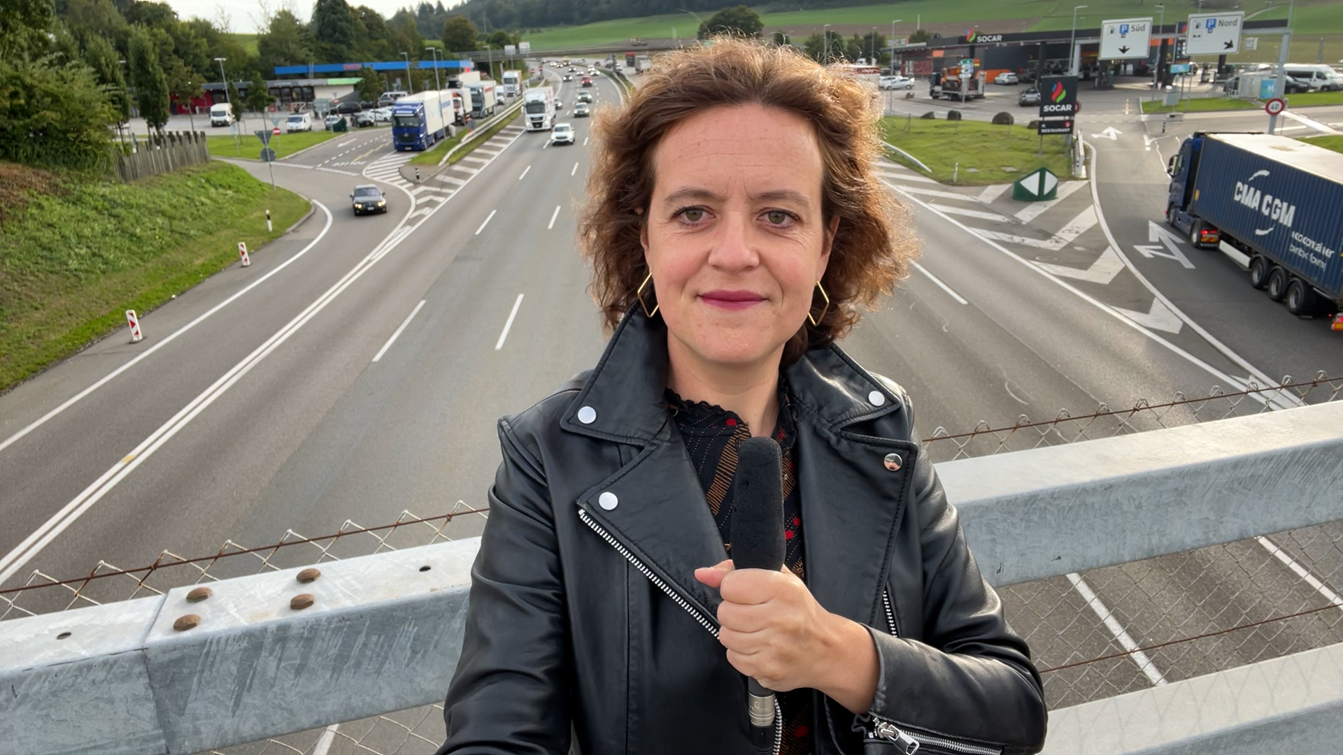 Femme avec un micro sur un pont d'autoroute