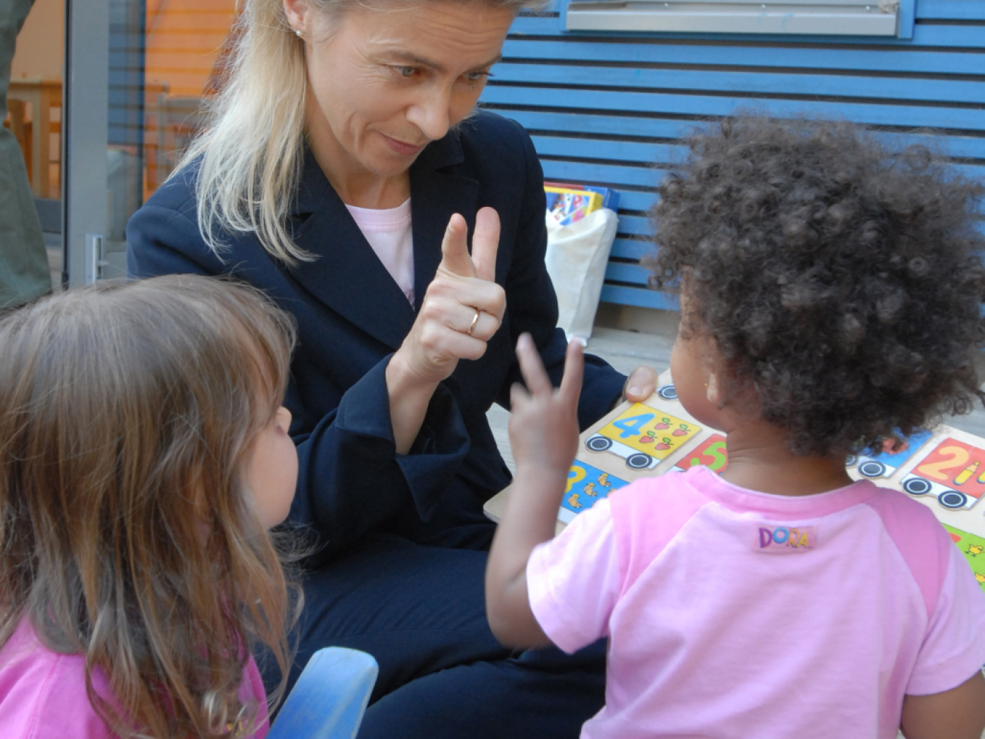 donna insegna a bambini a contare le dita della mano