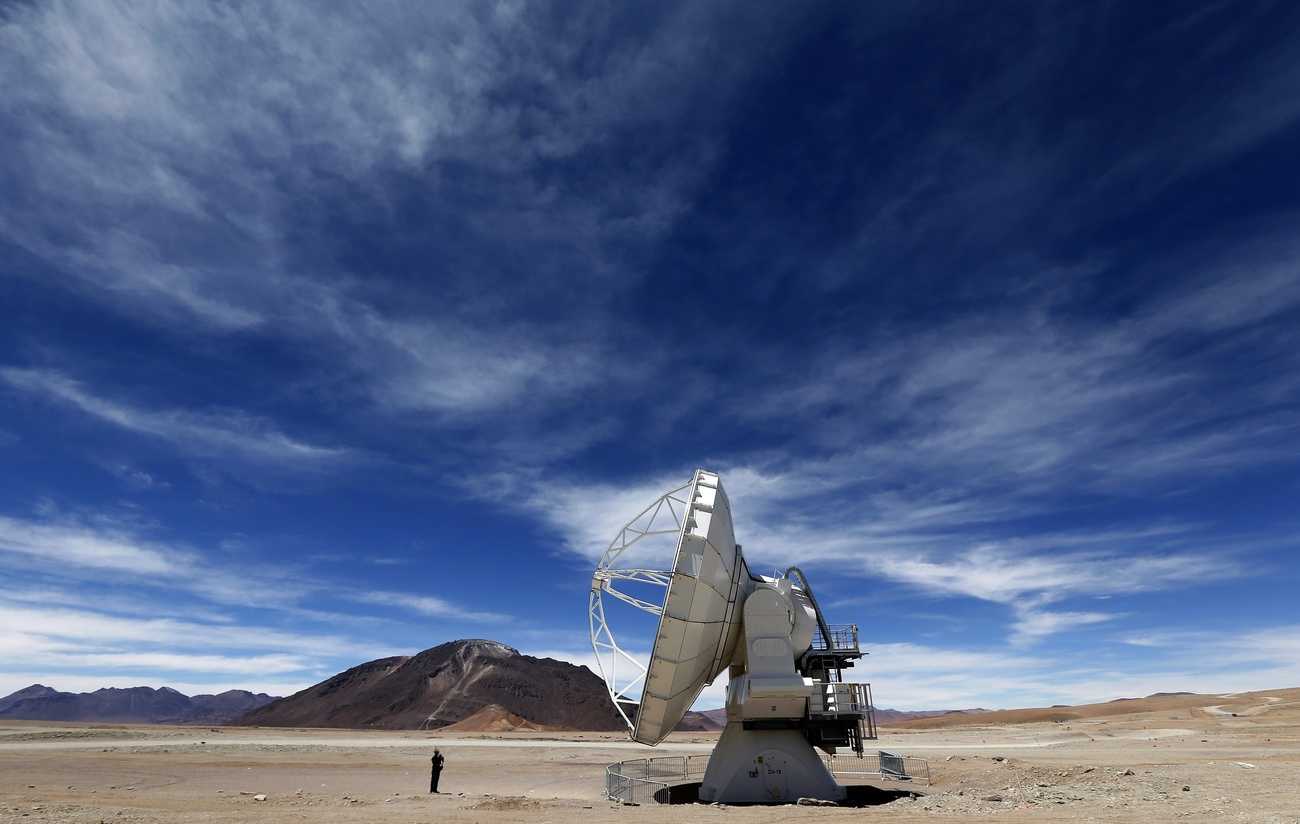 Un hombre toma una foto de una antena del Observatorio Atacama Large Millimeter Array (ALMA) en el Llano de Chajnantor, a unos 70 km de San Pedro de Atacama, Chile, el 12 de marzo de 2013. El Observatorio ALMA es considerado el observatorio terrestre más caro del mundo y funcionará con 66 antenas para observar el universo.