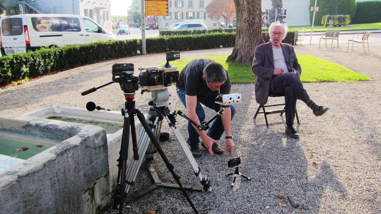 Aragno and Godard (sitting) on the set of "Goodbye to Language" (Adieu au langage), 2014.