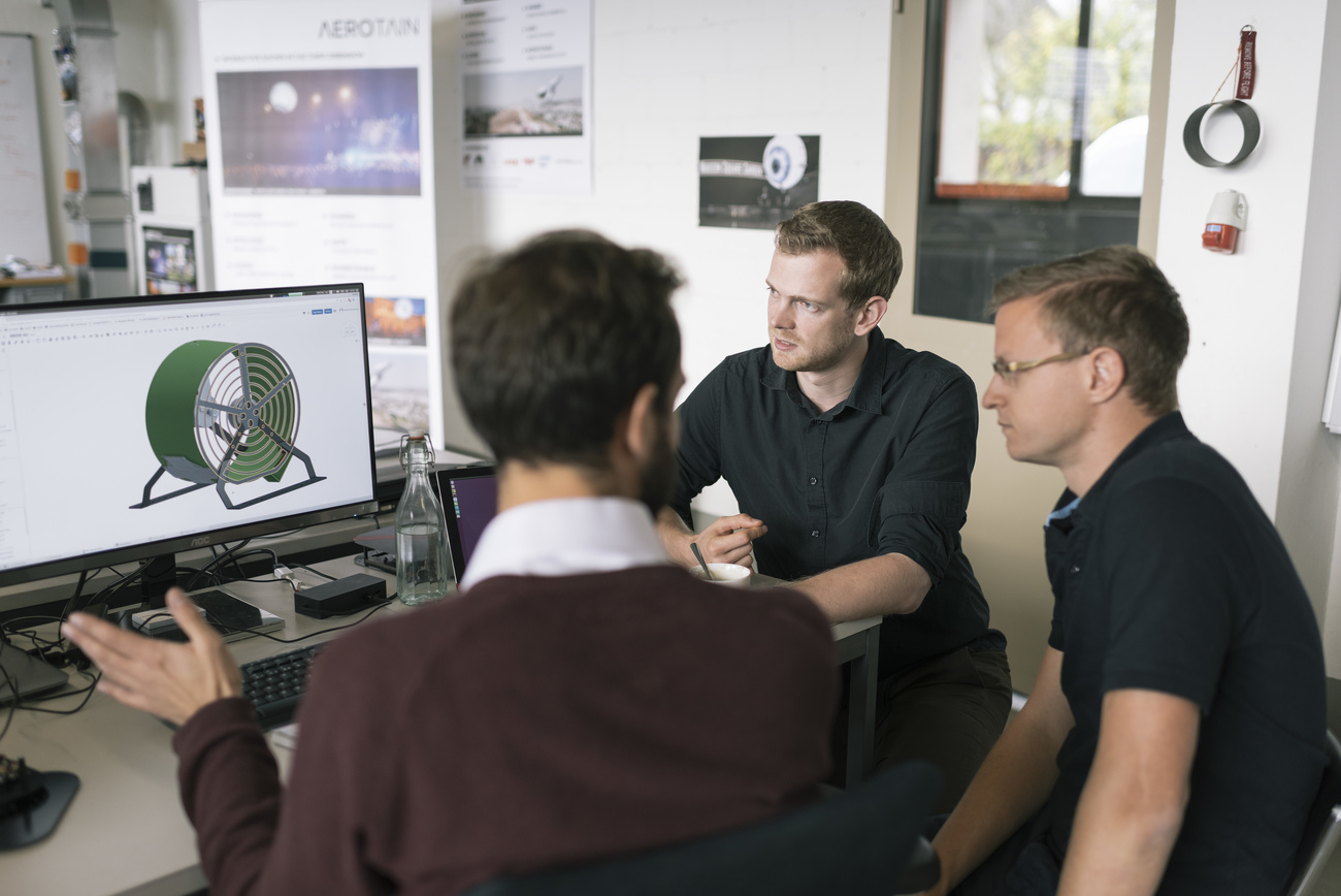 three men looking at a computer screen