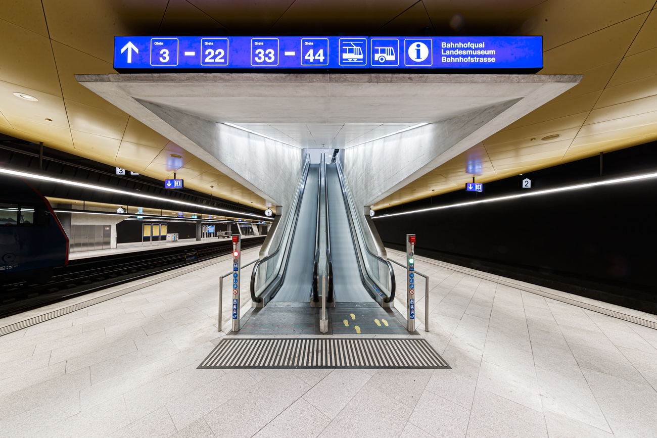 railway station showing escalator and blue signage