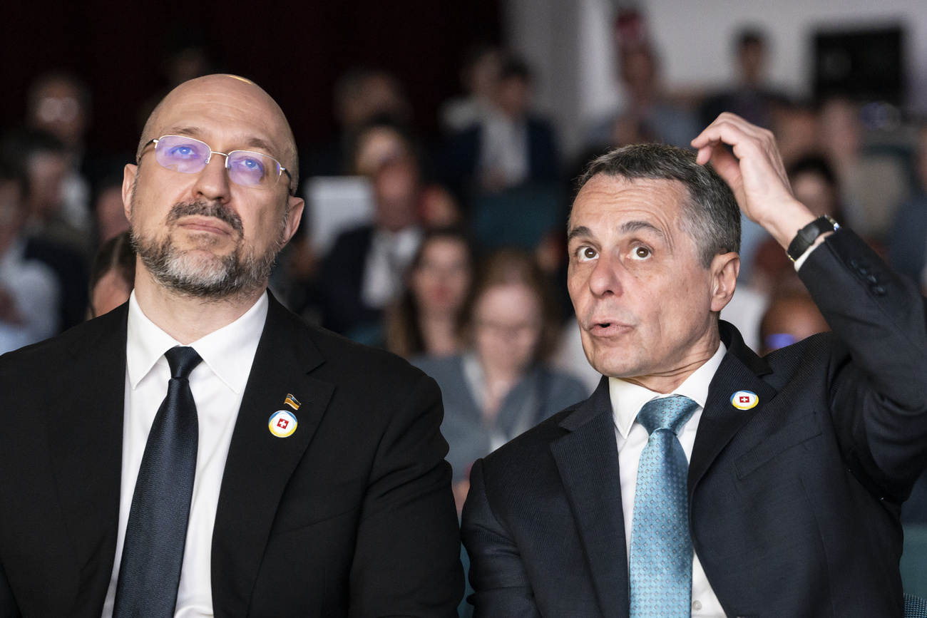 Swiss President Ignazio Cassis, Minister of Foreign Affairs, right, and Ukrainian Prime Minister Denys Shmyhal, left, speak before taking the stage during the Economic Forum official opening following the Ukraine Recovery Conference URC, Tuesday, July 5, 2022 in Lugano, Switzerland.