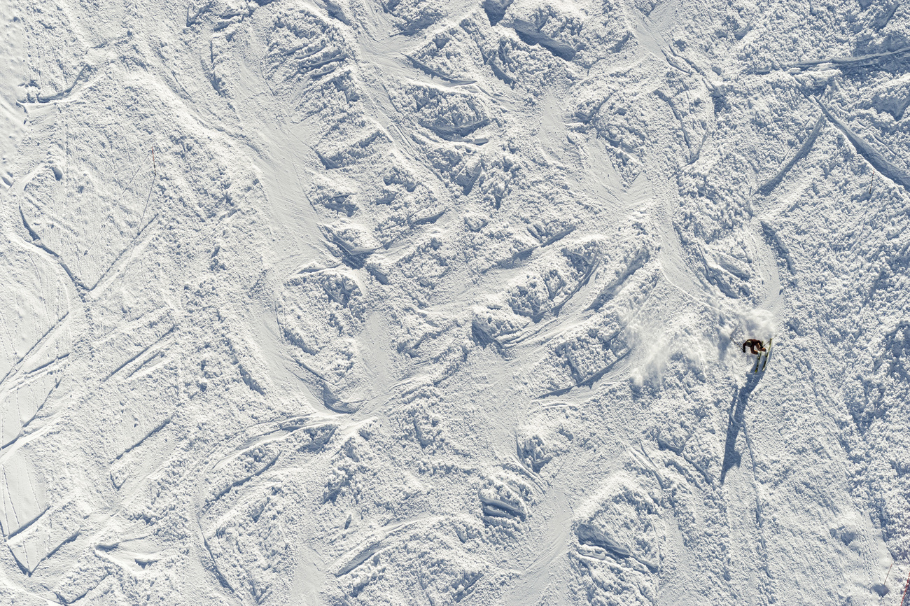 Spuren im Schnee einer Skipiste von oben fotografiert.