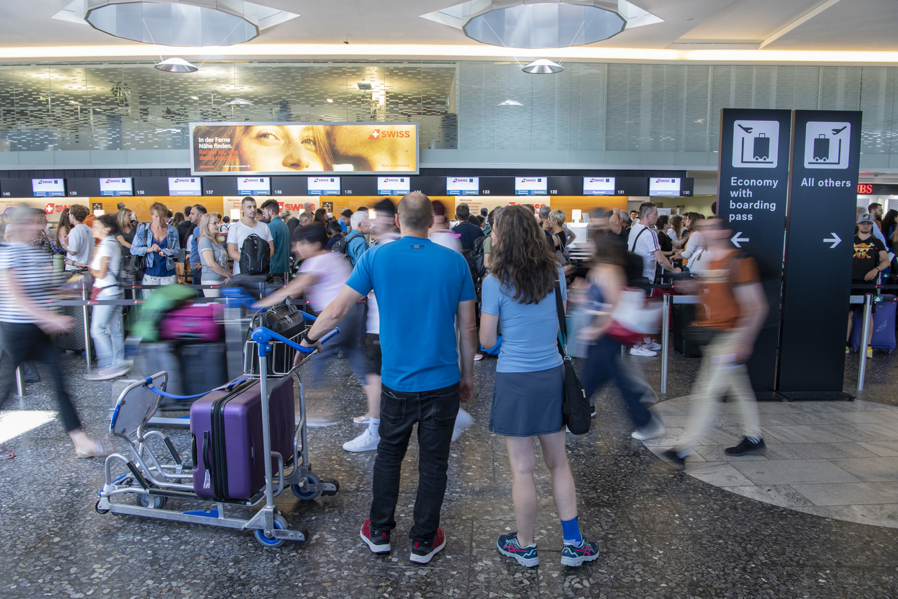 Persone in coda a un banco check-in.