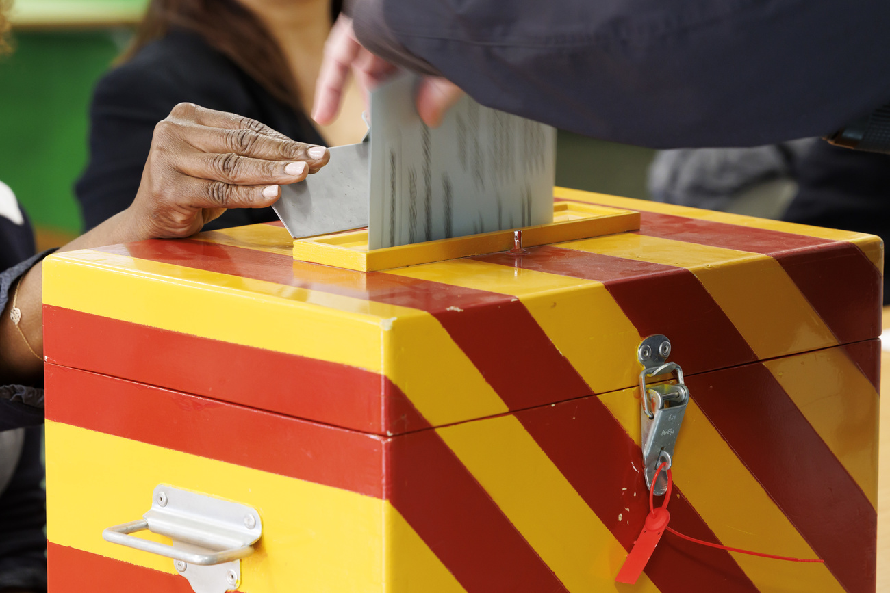 Main mettant un bulletin de vote dans une urne.