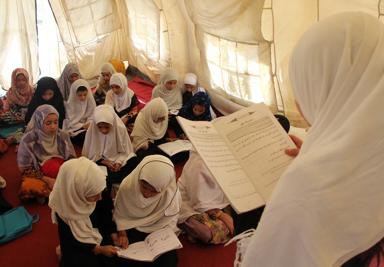 Afghan girls attend a class at the primary school after returning from the summer holidays.