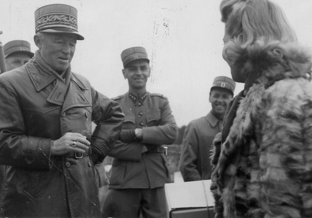 Foto em preto e branco exibindo militares e uma mulher