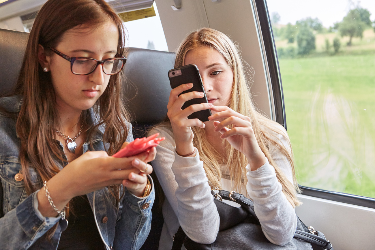 Zwei junge Frauen am Smartphone im Zug