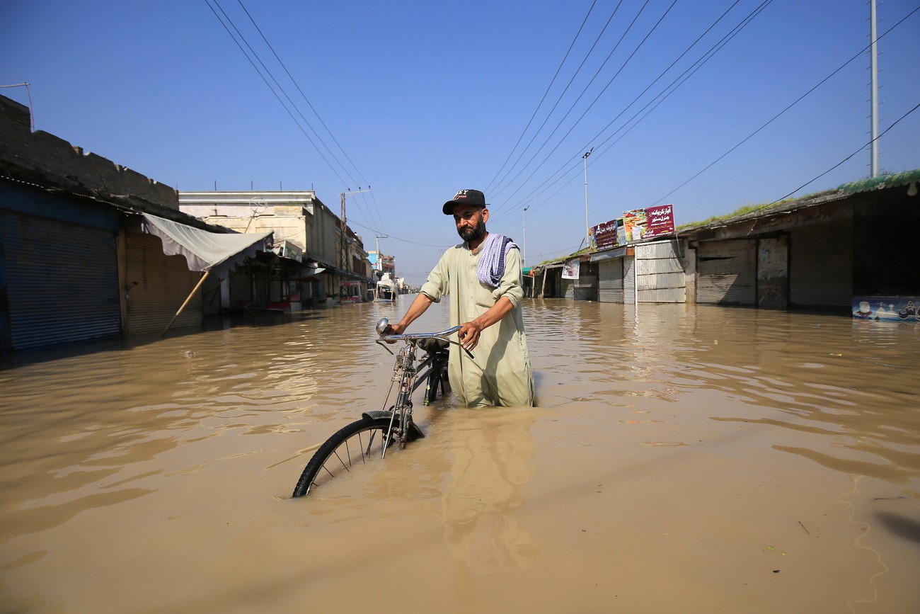 A man wades through a flooded area following heavy rains in Nowshera District, Khyber Pakhtunkhwa province, Pakistan.