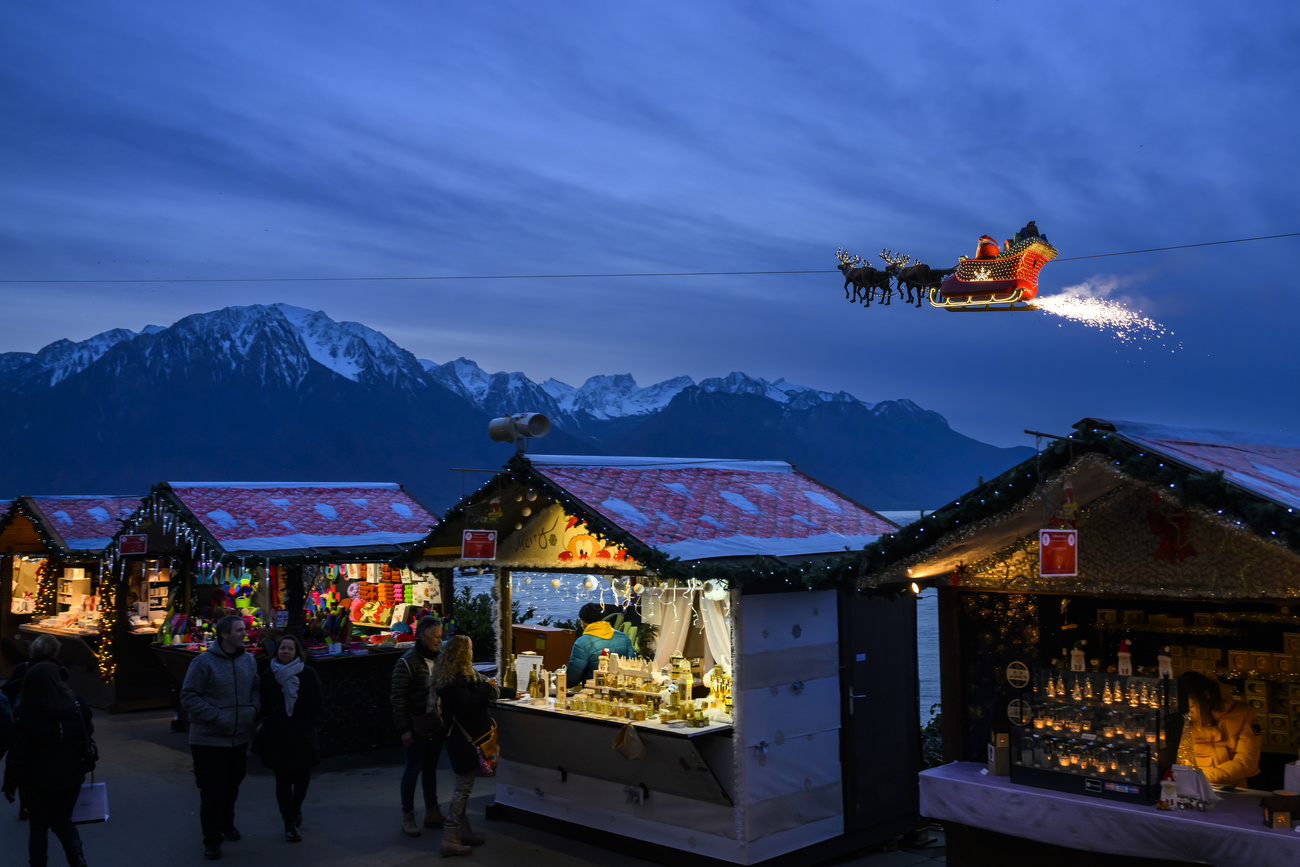 Un Pere Noel dans un traineau volant, circule sur un cable au-dessus des stands lors du Montreux Noel le jeudi 24 novembre 2022 a Montreux. Le Marche de Noel de Montreux accueil entre les chalets illumines, marchands, artisans et restaurateurs au bord du lac Leman lors de la periode du 18 novembre au 24 decembre. (KEYSTONE/Jean-Christophe Bott)