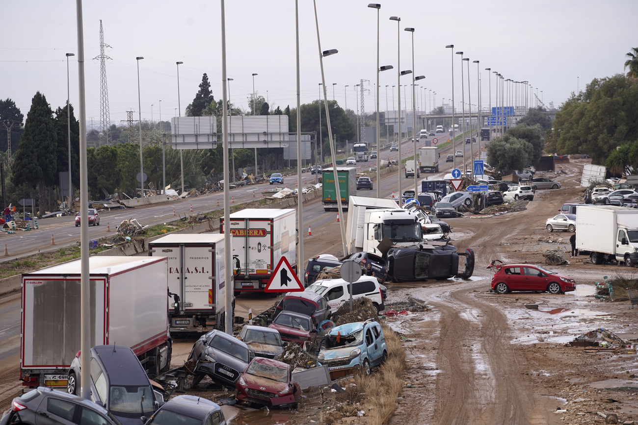 Los coches están esparcidos al lado de una carretera principal tras las inundaciones en Valencia, España.