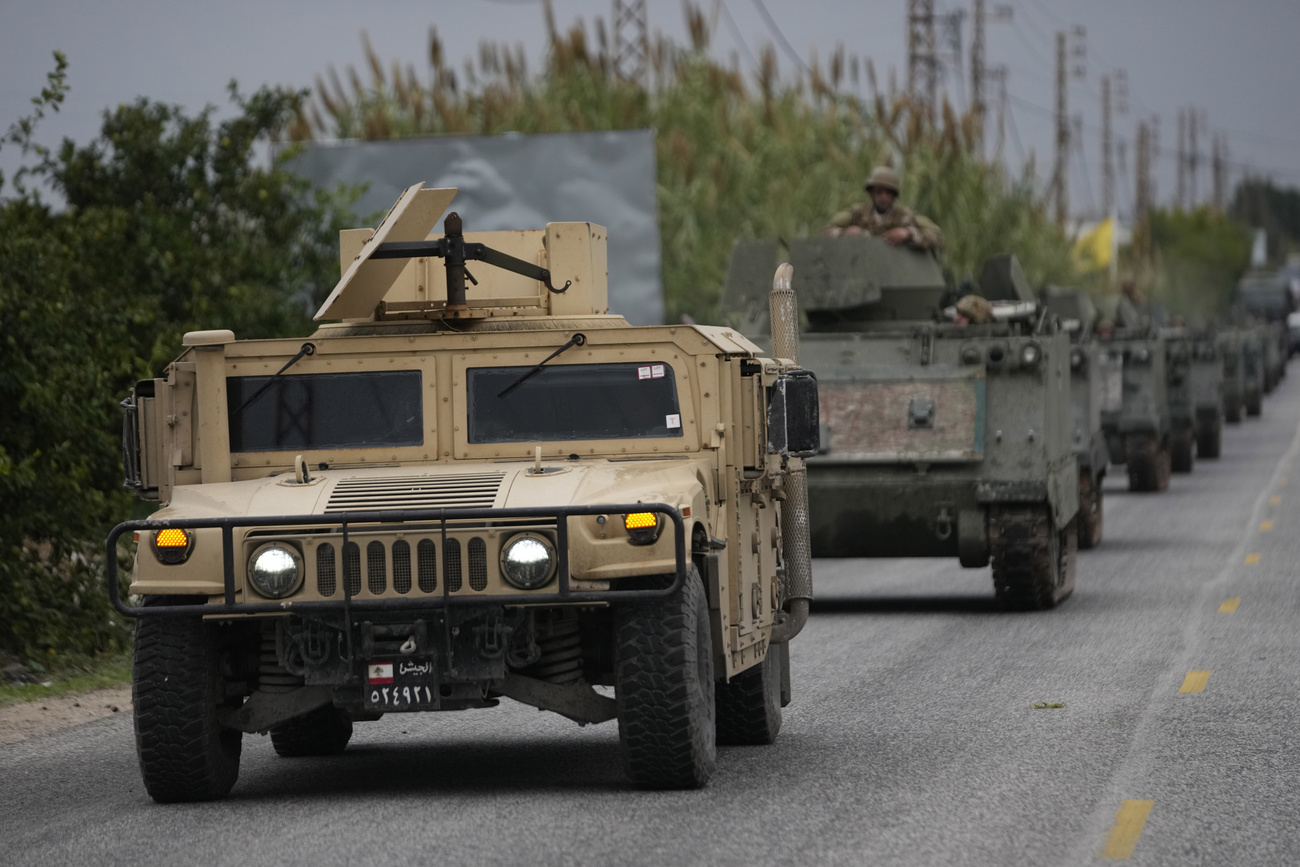 Lebanese soldiers ride in a convoy in Mansouri as they head to southern Lebanon, following a ceasefire between Israel and Hezbollah that went into effect on Wednesday, Nov. 27, 2024. (AP Photo/Hussein Malla)