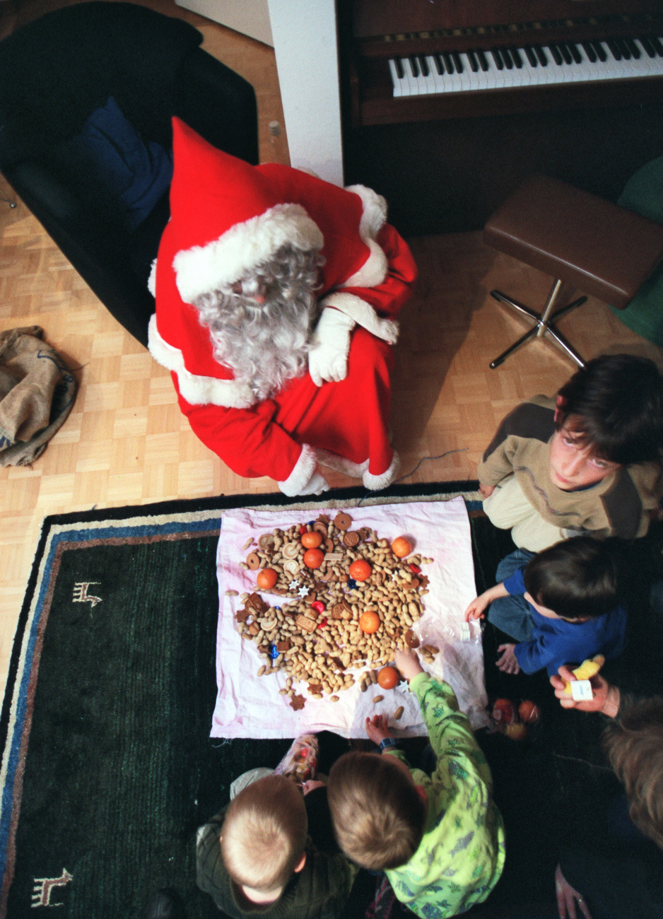 Father Christmas brought nuts, mandarins and sweets to a family in Thalwil on 6 December 2003. (KEYSTONE/Gaetan Bally) === , , NO INTERNET, TV OUT, EDITORIAL USE ONLY, FILM === : FILM]