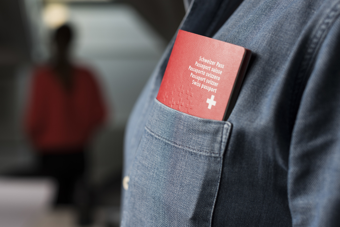 un passeport suisse dans la poche d'une chemise en jean.