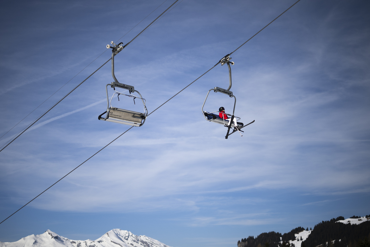 Un sciatore solitario su una seggiovia di Arosa.