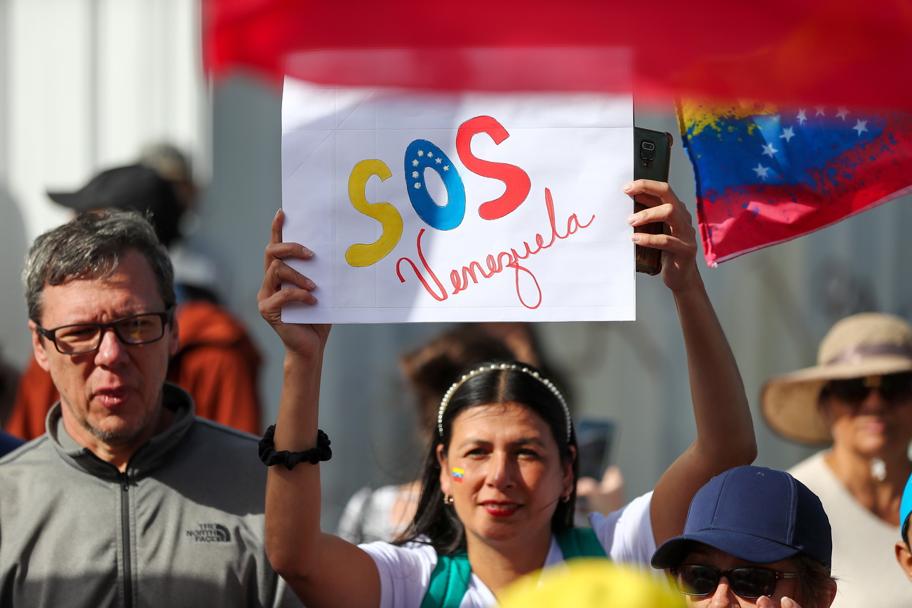 Woman holding up sign SOS Venezuela in Quito, Ecuador.