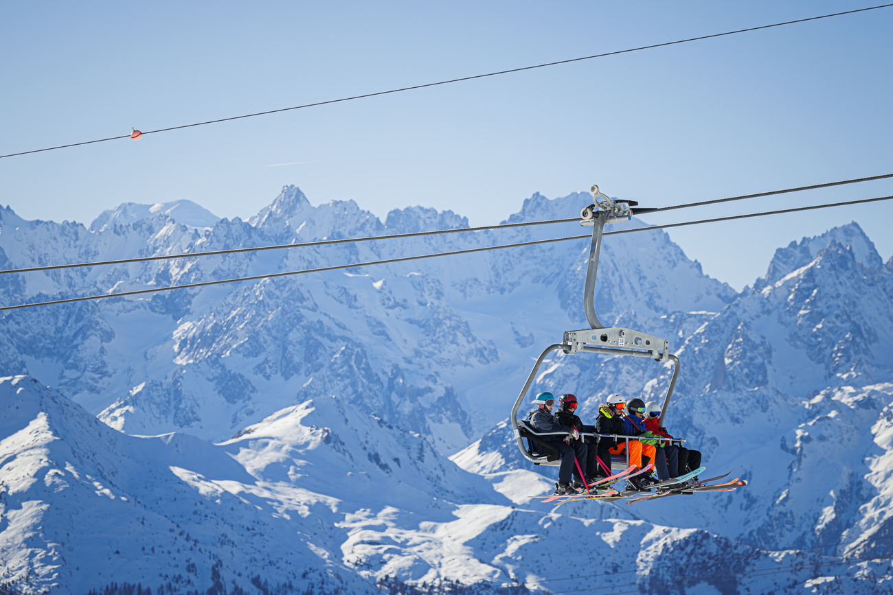 Skiers ride a lift as they enjoy the snow and sunny weather during one of the first weekends after the opening of the ski season in the alpine resort of Verbier, Switzerland,