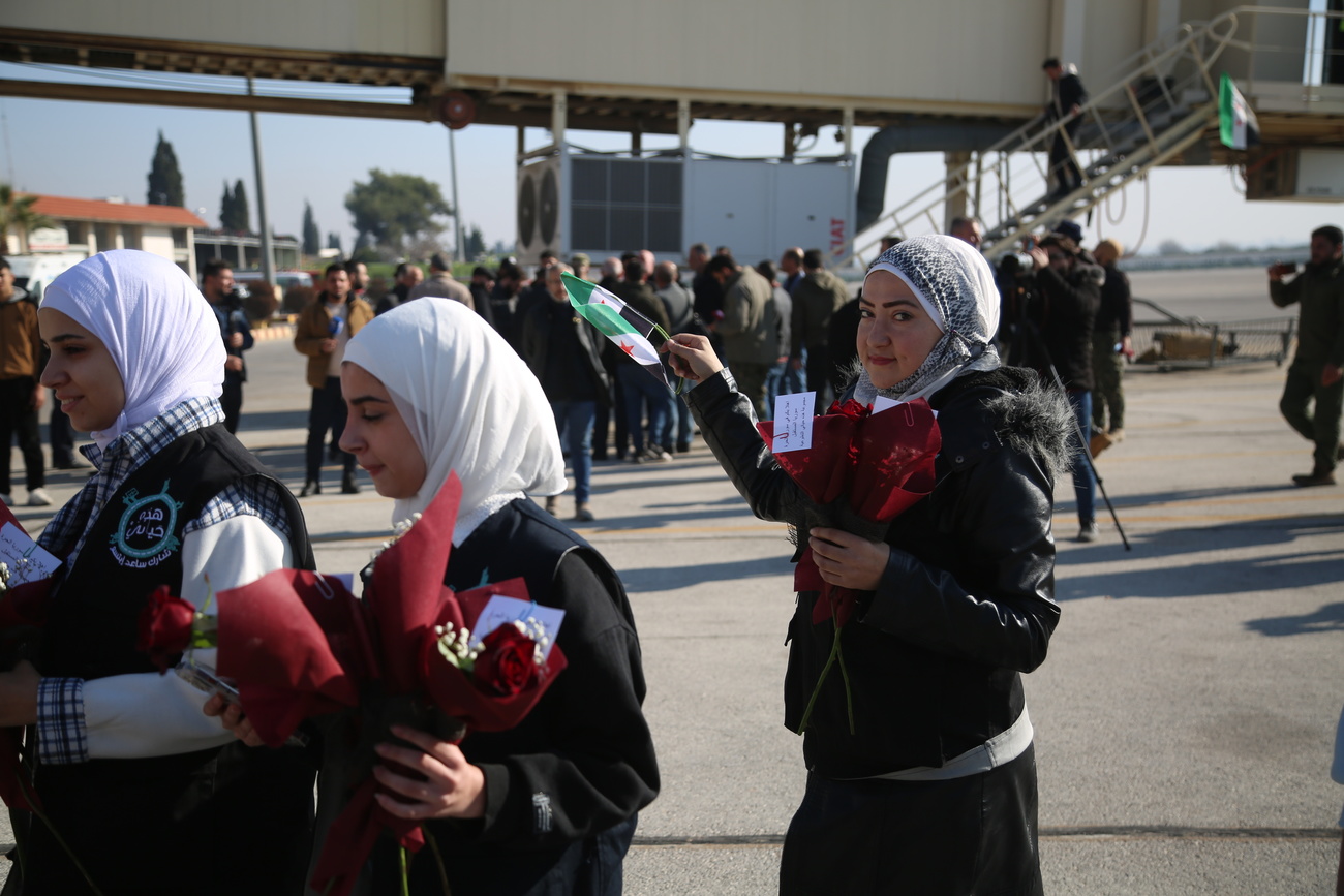 متطوعات يحملن الورود في مطار حلب الذي أعيد افتتاحه لأول مرة منذ الإطاحة بالرئيس بشار الأسد، حلب، سوريا، 18 ديسمبر 2024.