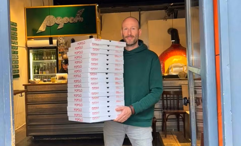 Restaurateur tenant un paquet de pizzas à livrer