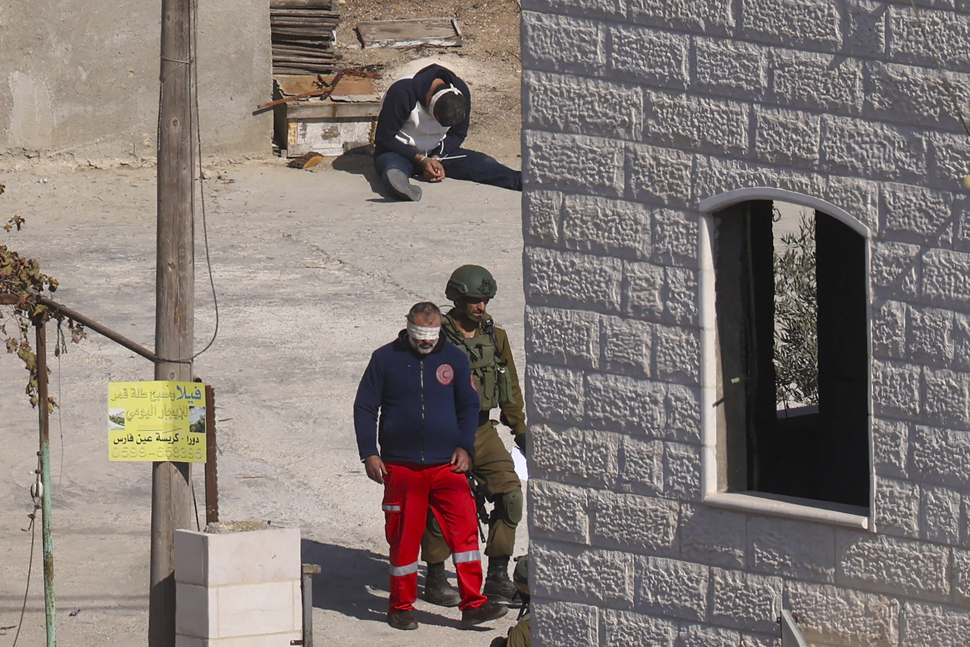 Ein israelischer Soldat und ein festgenommenes Mitglied des Palästinensischen Roten Halbmonds