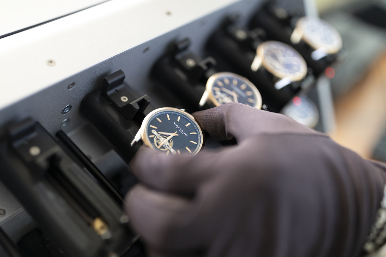 A watchmaker places watches of the Swiss luxury watch brand Raymond Weil on a device intended for a quality test, in Geneva, Switzerland, on October 8, 2018.