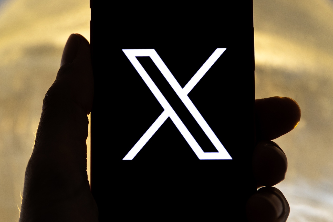 Ein Handy, auf dem Display ein grosses Logo von "X"