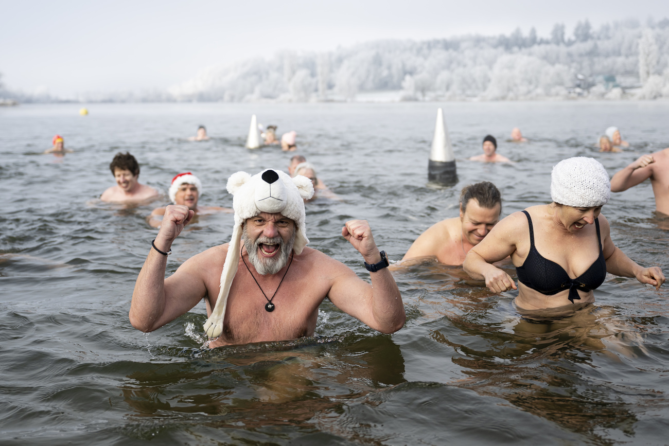 Swimmers swim during the traditional Sylvester swim at lake Moossee in Moosseedorf, Switzerland, Tuesday, December 31, 2024. The tradition has existed since 1999. On December 31, around fifty bathers gathered at the "Moossee" lake in Moosseedorf (BE) to take a dip in water measured at between 4 and 5 degrees Celsius. The story goes that the end-of-year bath washes away old sins, allowing the New Year to pass with a purified body and mind. The New Year's Eve swim is organized by the "Ysheilige Moossee" winter swimming club. (KEYSTONE/Anthony Anex)