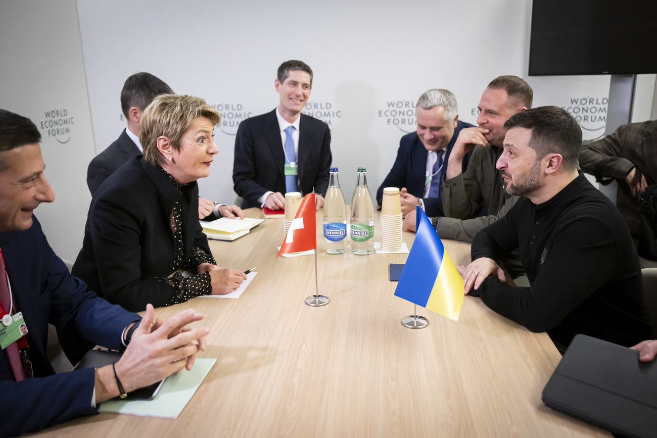 Karin Keller-Sutter und Wolodimir Selenski an einem Sitzungstisch mit ihren Delegationen. Die Stimmung scheint gut, alle haben ein Lächeln auf den Lippen.