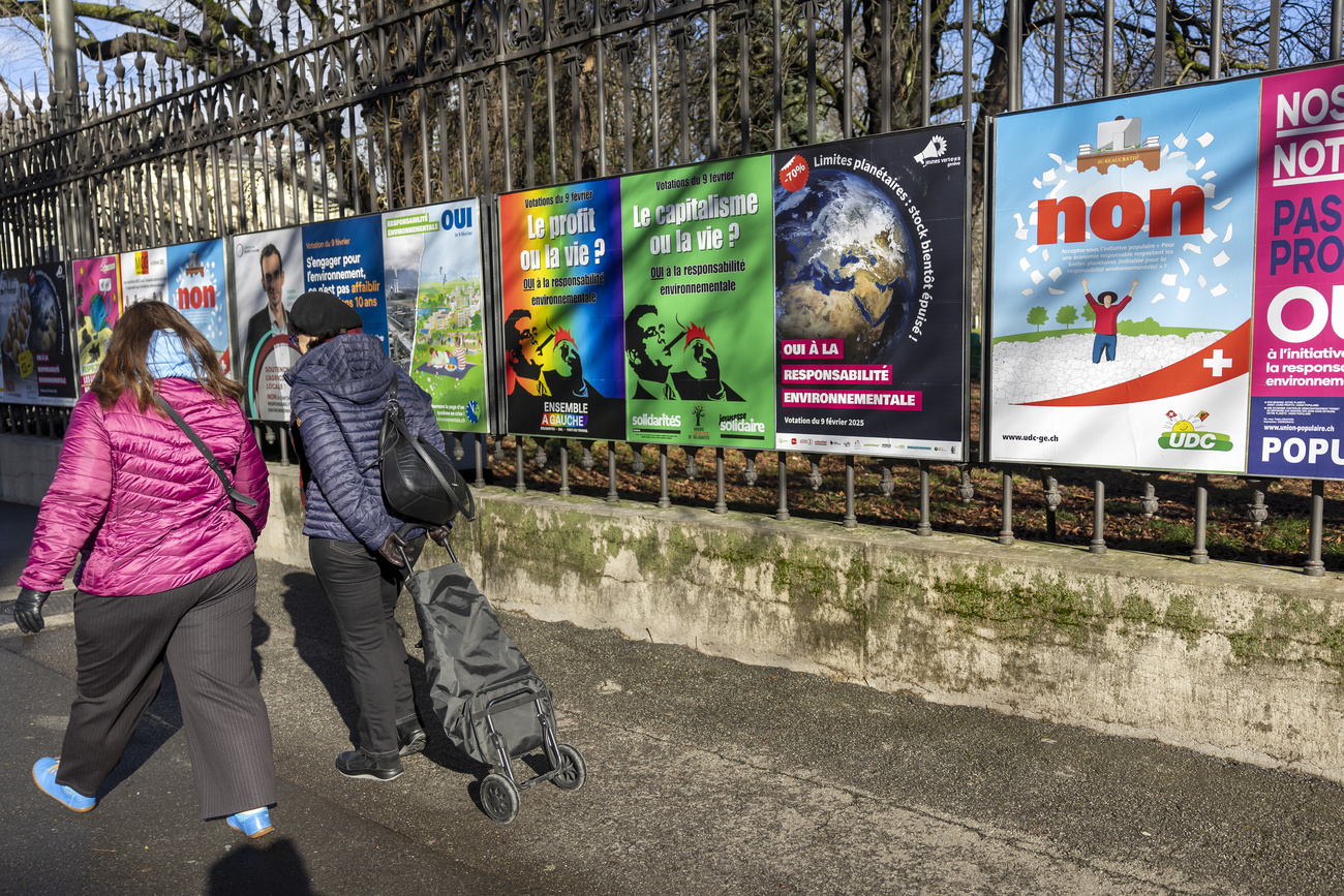 Zwei Passantinnen gehen an Abstimmungsplakaten vorbei