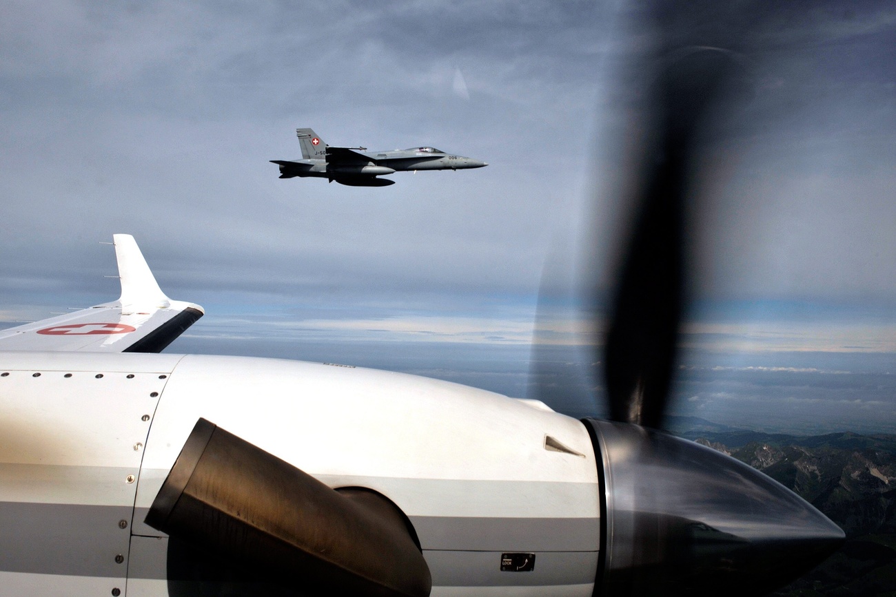 A FA18 Hornet from the Swiss Army flies next to a civil plane during an excercise of air Policing in collaboration with Italian Air Force in the new cross border area between Italy and Switzerland, over the Alps in Switzlerand, Tuesday June 8, 2010.