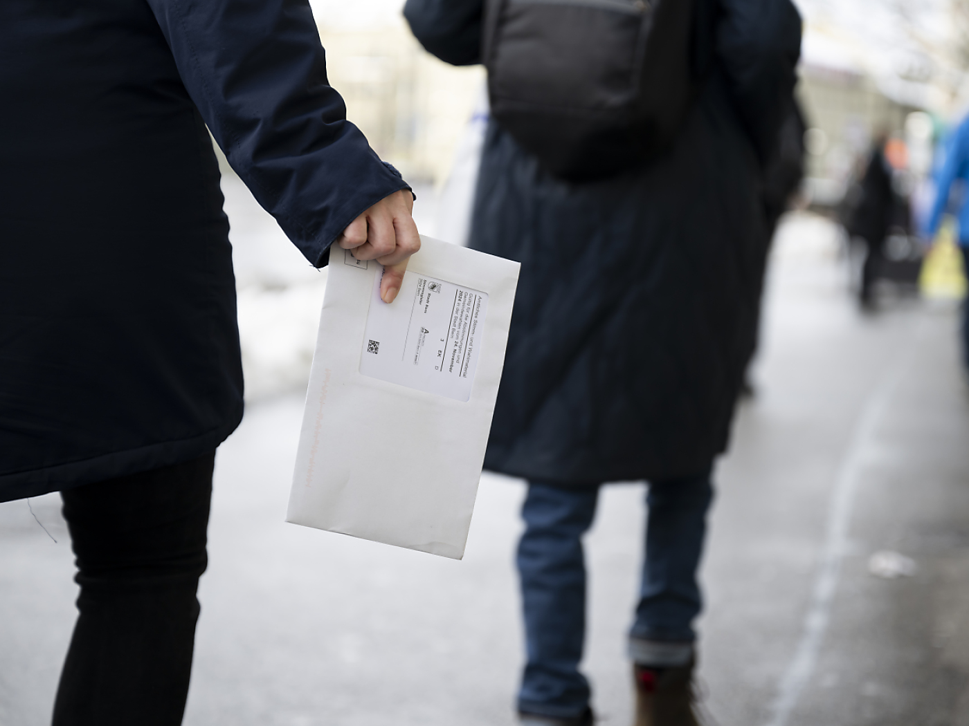 persona con in mano bollettino di voto