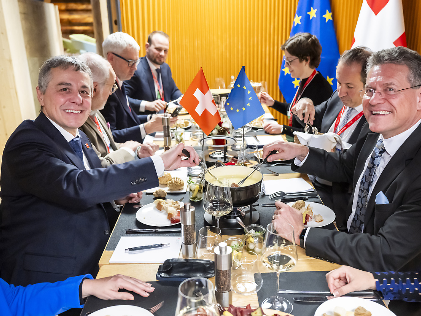 sefcovic e cassis sorridono mentre mangiano la fondue