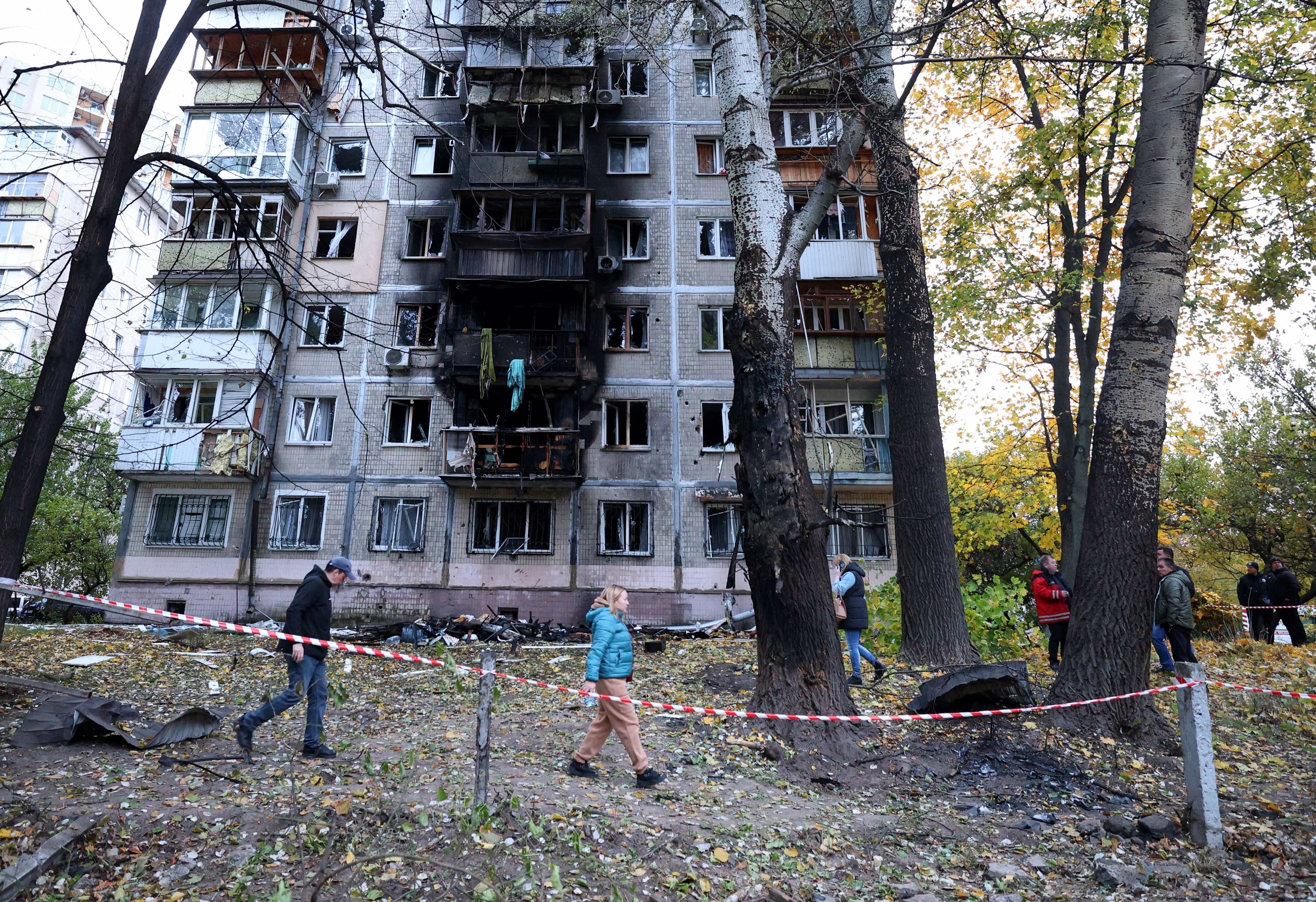 Local residents walk around a building damaged by the explosion of a drone strike in Kyiv, on October 30, 2024. (Photo by Anatolii STEPANOV / AFP)