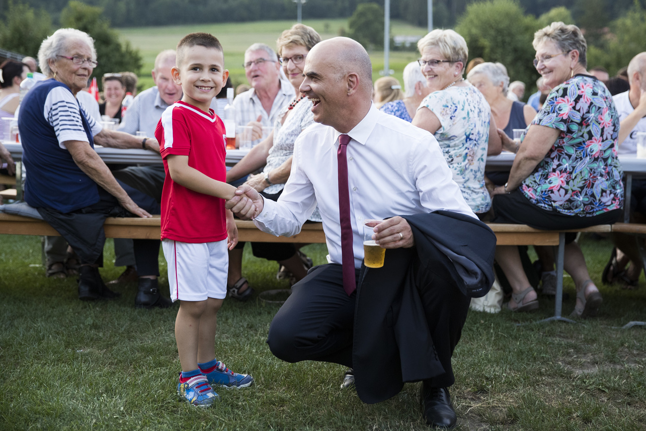 Un abitante di Belfaux, nel canton Friburgo, accoglie l'allora Presidente della Confederazione Alain Berset nel suo luogo di attinenza in occasione della Festa nazionale nel 2018. Berset ha poi tenuto un discorso.