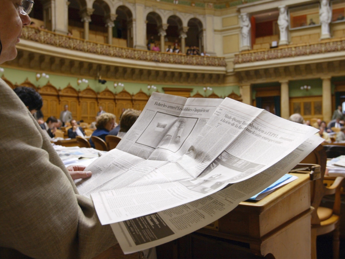 persona legge giornale nella sala del consiglio nazionale