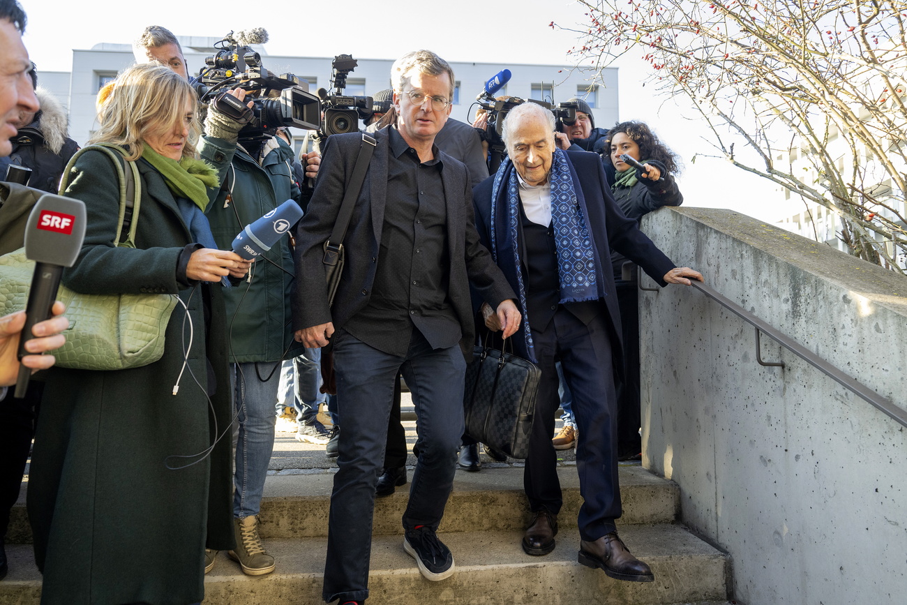 Former FIFA President Joseph Sepp Blatter (R front) is surrounded reporters as he arrives at the special appeals court in Muttenz, near Basel, Switzerland, on March 3, 2025.