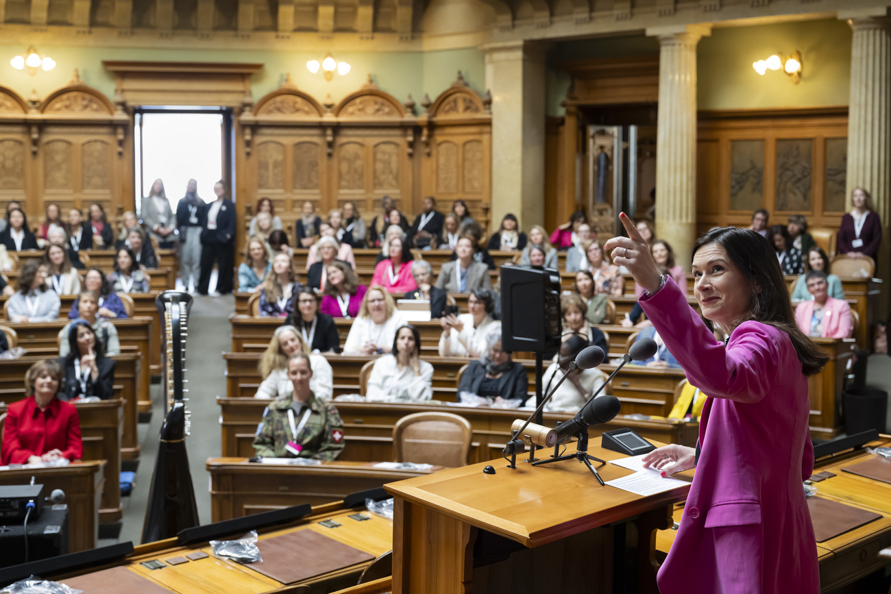 Around 400 women from all over Switzerland are meeting at the federal parliament in Bern today on the eve of International Women's Rights Day. They will be discussing this year's theme, "Women and Security". The meeting was organised by Maja Riniker, president of the House of Representatives and member of the Radical-Liberal Party, seen giving a speech in the picture of the day above.